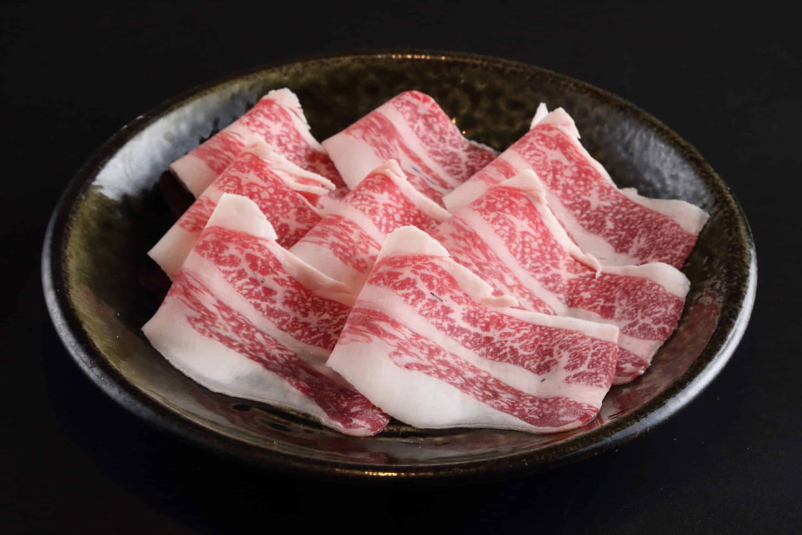 黒い皿に盛った霜降り肉のスライス