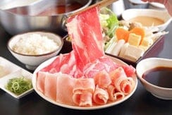 しゃぶしゃぶ鍋に牛肉のスライスを入れる様子