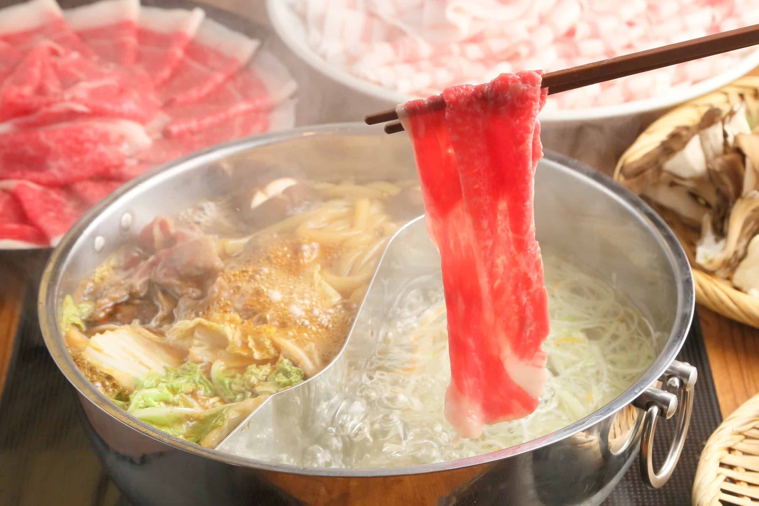 鍋に牛肉のスライスをくぐらせるしゃぶしゃぶの様子