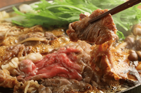 すき焼き鍋で煮える牛肉と青菜